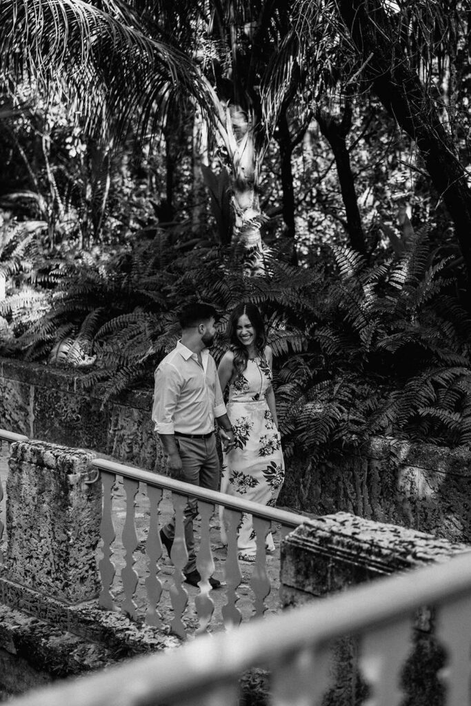 a couple walks through the alleys of their engagement photo shoot location in Miami