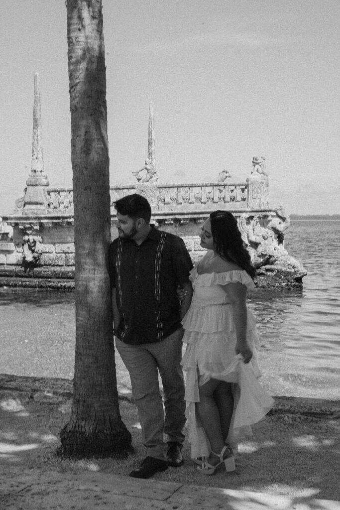 a couple looks to the right while standing in front of the water structure at Vizcaya in Miami