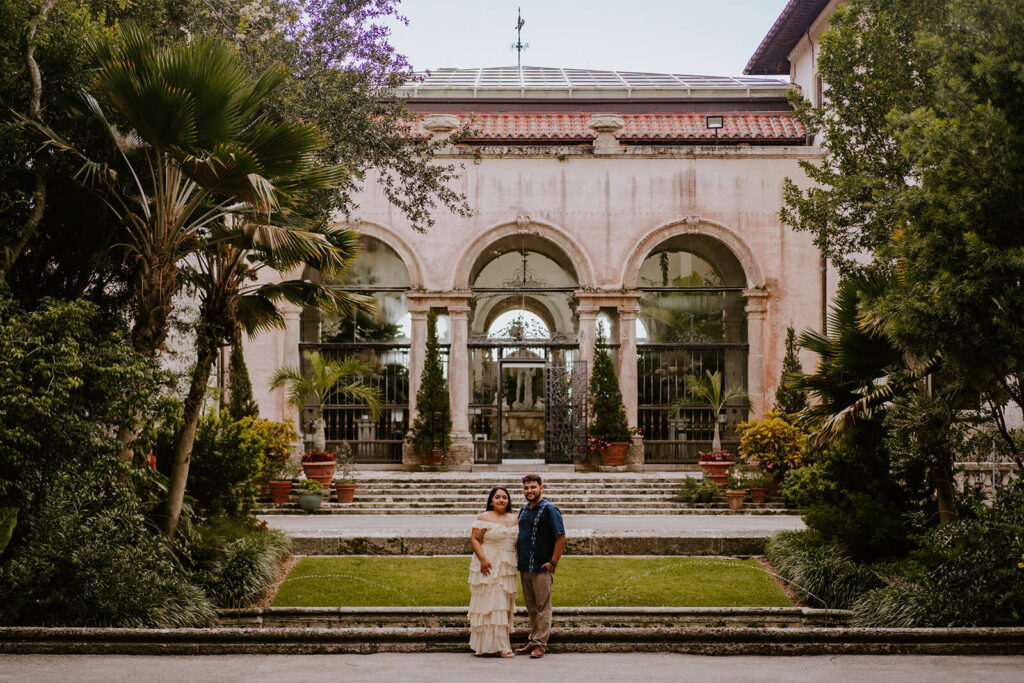 a couple standing outside the entrance of Vizcaya Museum & Gardens in Miami