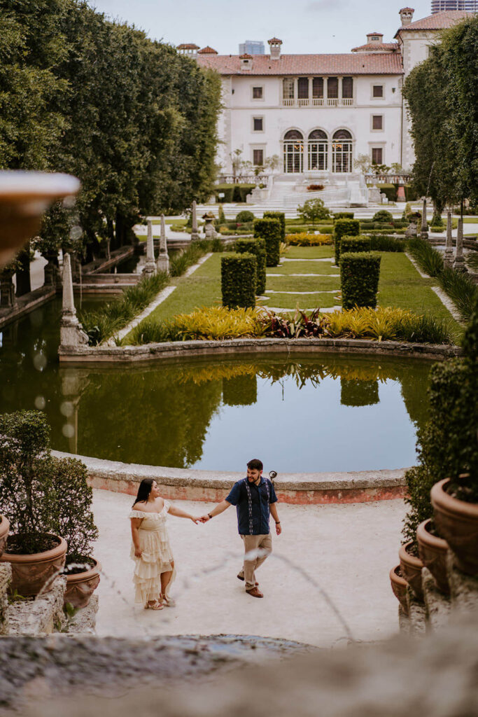 a couple walks through the gardens of Vizcaya Museum in Florida