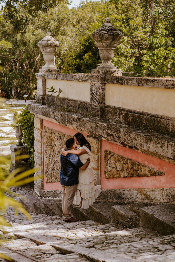 a couple poses on the staircase at the gardens of Vizcaya