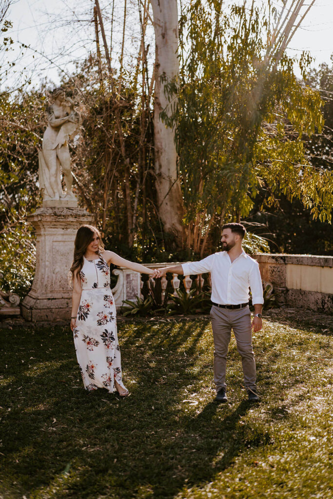a couple walks hand in hand in the grounds of their Miami wedding venue
