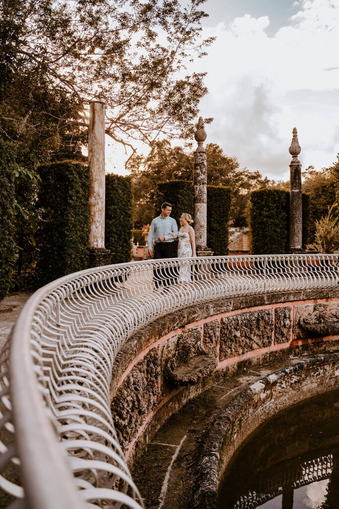 a couple walks throughout the courtyards of the grand Vizcaya Gardens