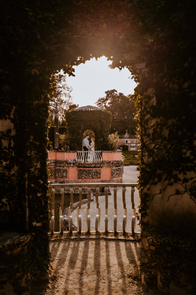a couple with their foreheads touching inside of one of the arches at Vizcaya Museum