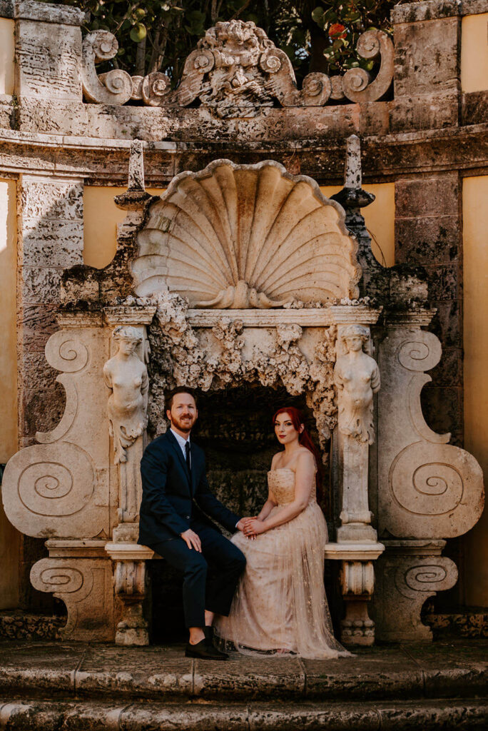 a couple sits inside a structure inside the gardens of Vizcaya in Miami
