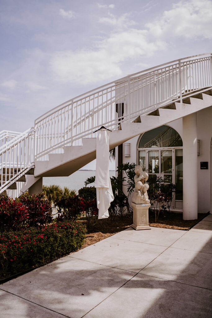 a wedding dress hanging from an outside staircase at a wedding venue in miami