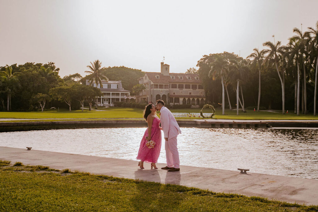 a bride and groom kiss in front of the Deering Estate in Miami florida