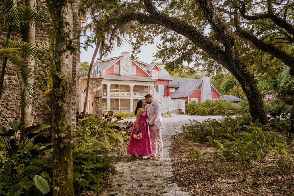 a bride and groom hug in front of their luxury wedding venue in Miami, the deering estate
