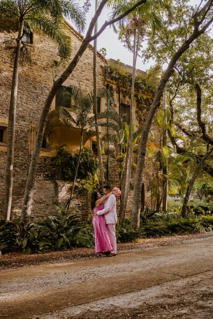a bride and groom hugging in front of one of the estates at their luxury wedding venue in miami
