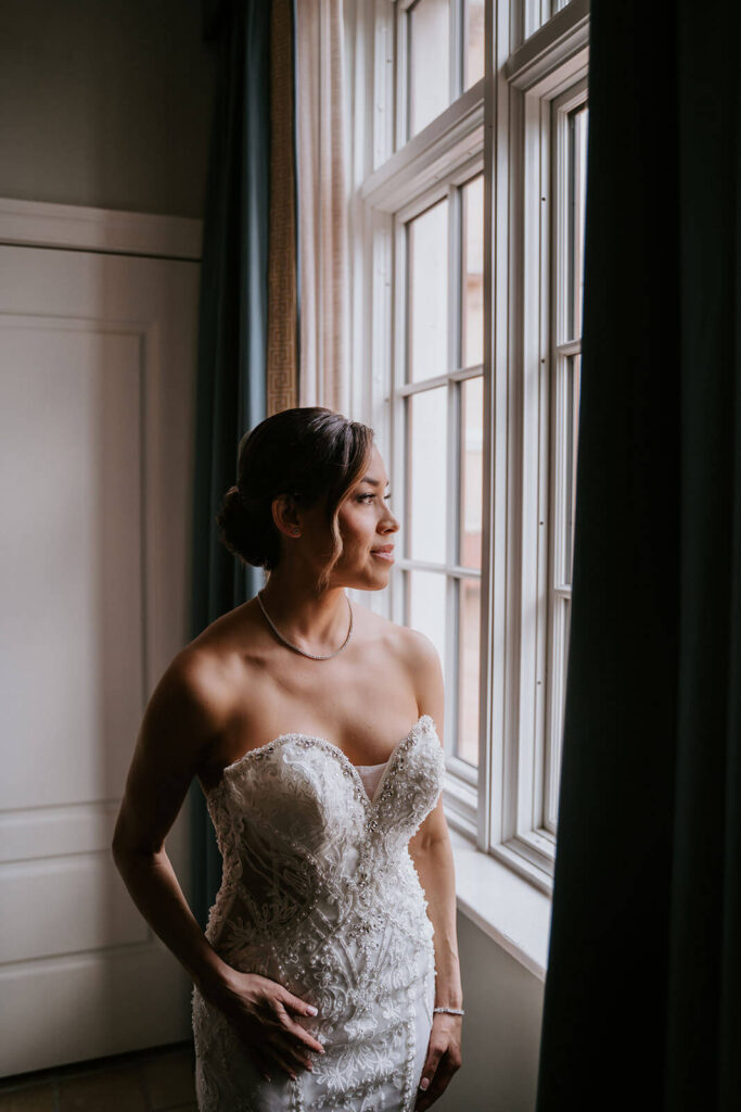 a bride looks out the window before her wedding at her luxury miami wedding venye