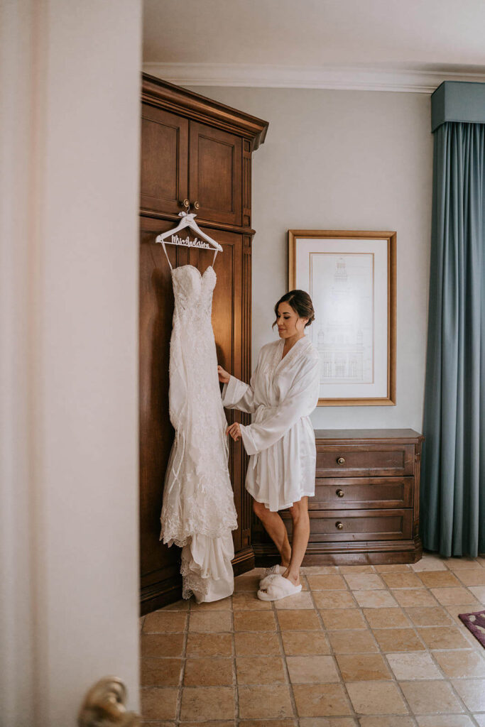 a bride looks at her dress while getting ready for her wedding at the Biltmore hotel in Miami