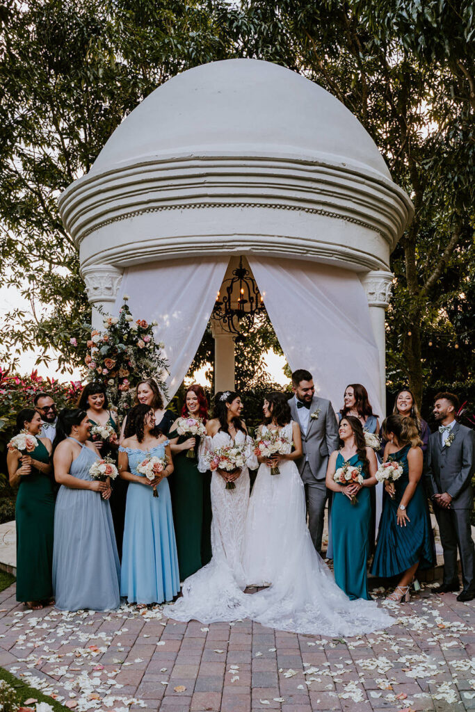 a bridal party pose for a photo with the 2 brides at a wedding at the Villa Toscana in Miami