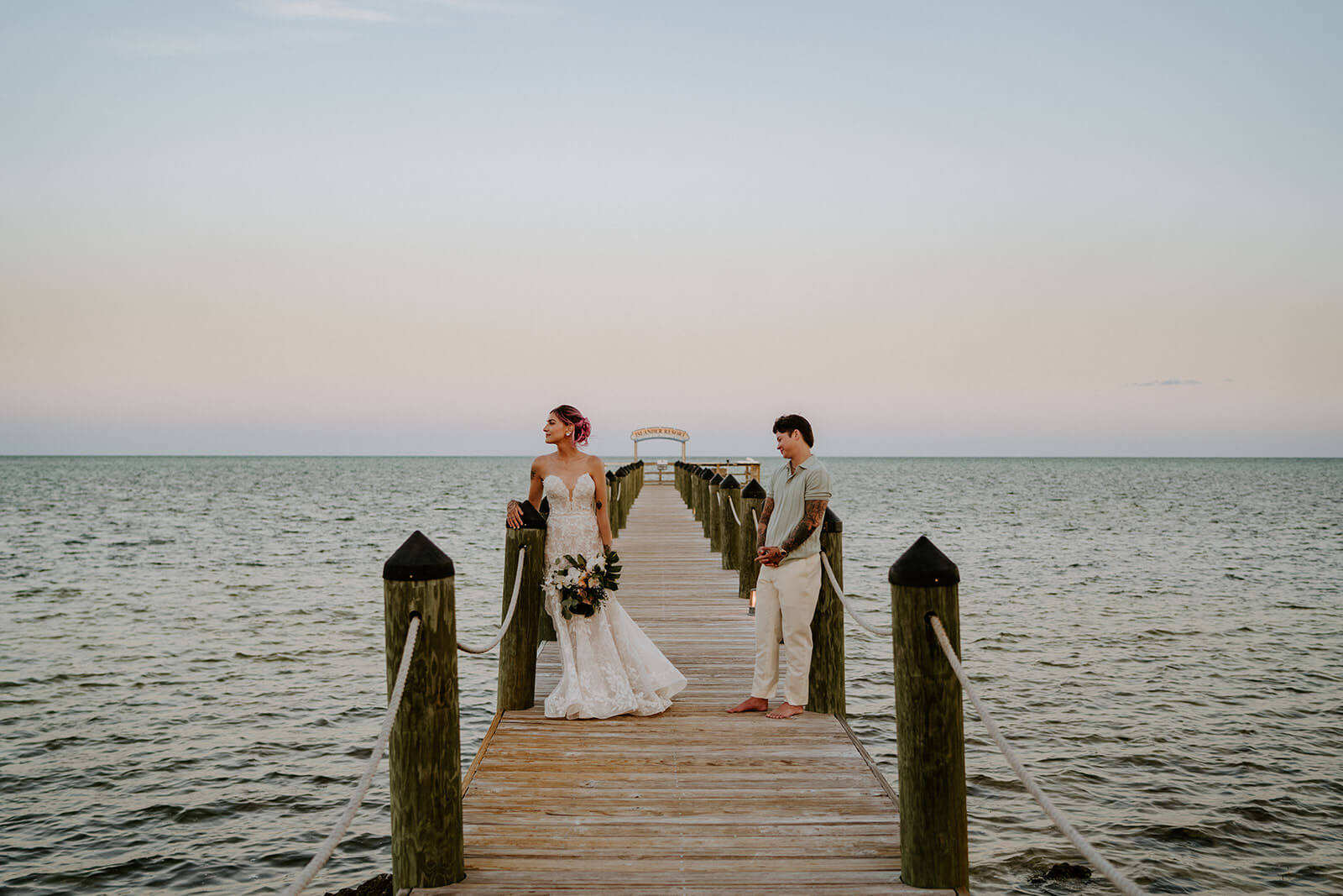 a couple posing on their wedding day on a dock on the water at the islander resort