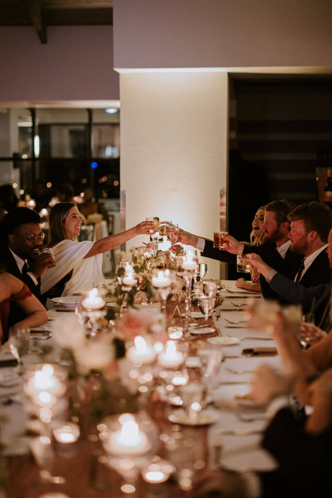 a table of wedding guests toasting their drinks after a speech at a wedding in miami florida
