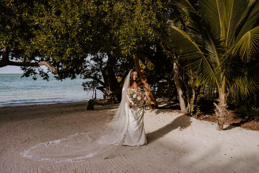 a bride posing with her bouquet and veil as she gets married in miami
