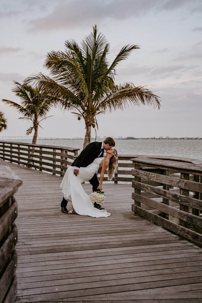 a grooms dips his bride at a walkway at their wedding at Tuckahoe Mansion