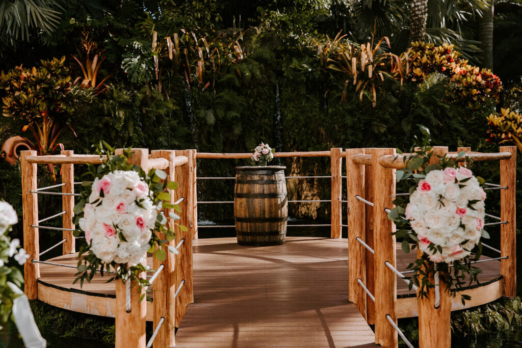 a ceremony deck that is located over a pond and in front of a beautiful waterfall at the wedding venue longans place