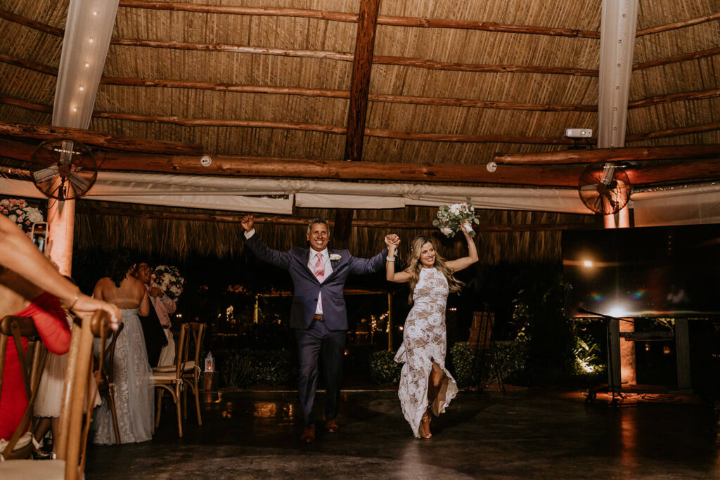 a bride and groom enter their wedding reception while cheering