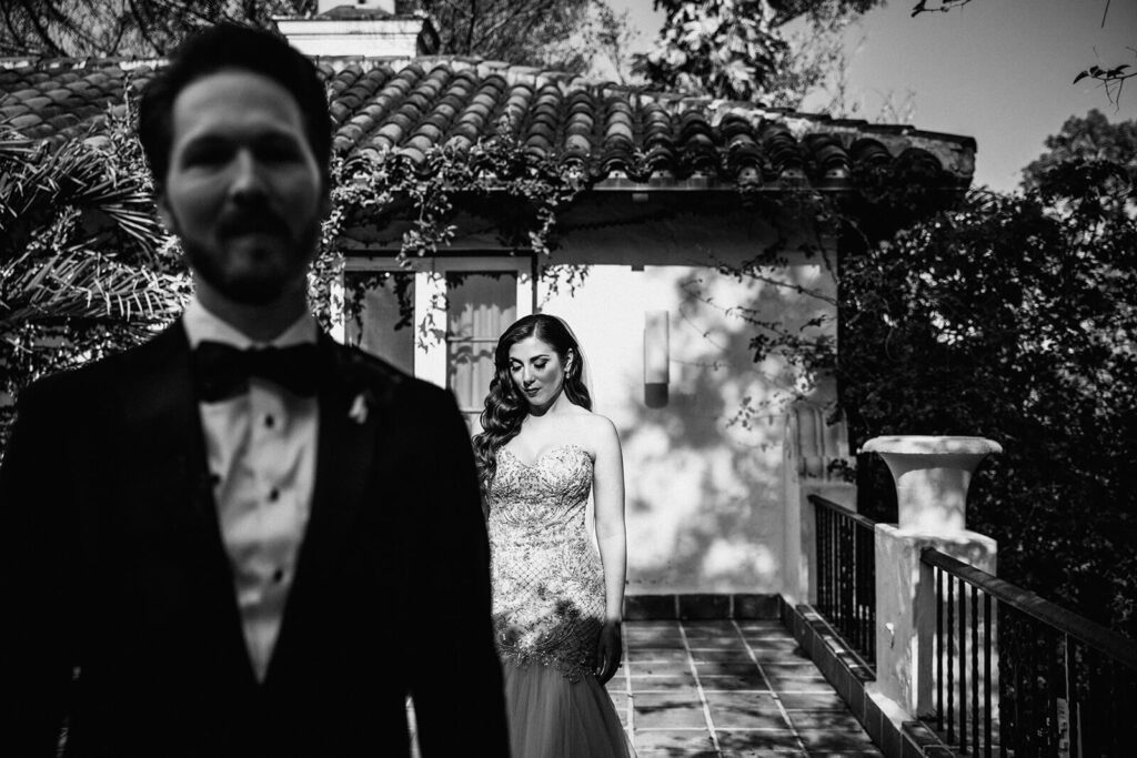 a bride walks up to her groom for their first look on the balcony of their coconut grove wedding venue