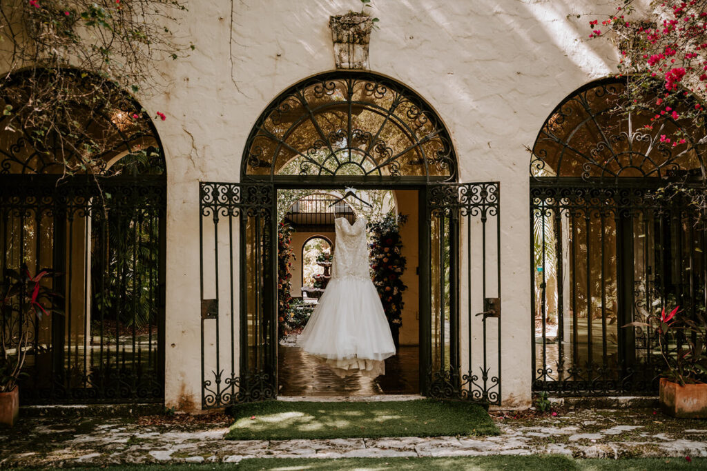 a photo of a brides dress hanging in an arch at Villa Woodbine in Coconut Grove