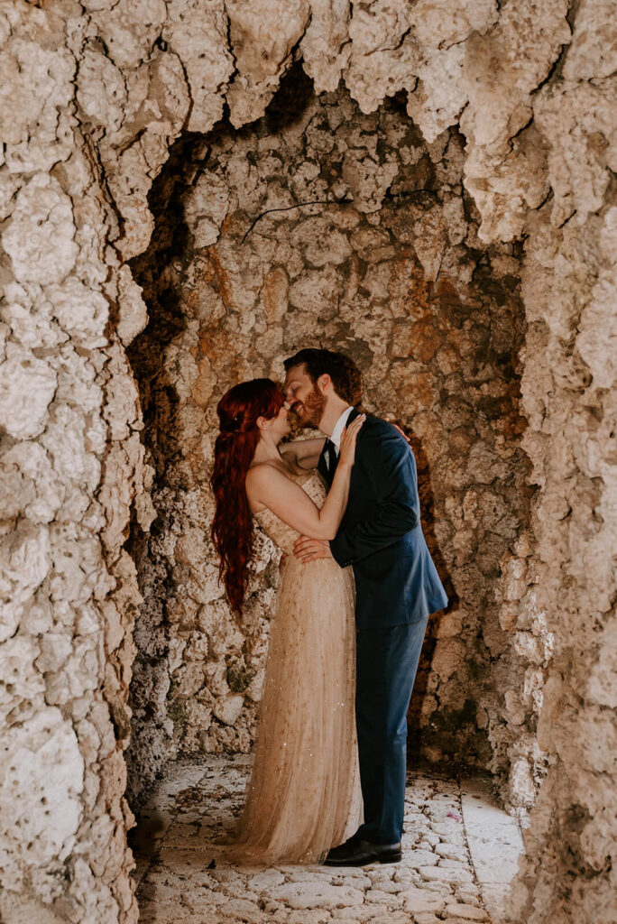 a couple kisses inside a cave at Vizcaya Museum and Gardens