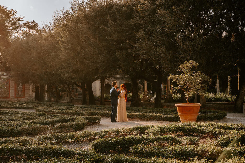 a couple stands in the middle of the beautiful gardens on their wedding day at Vizcaya