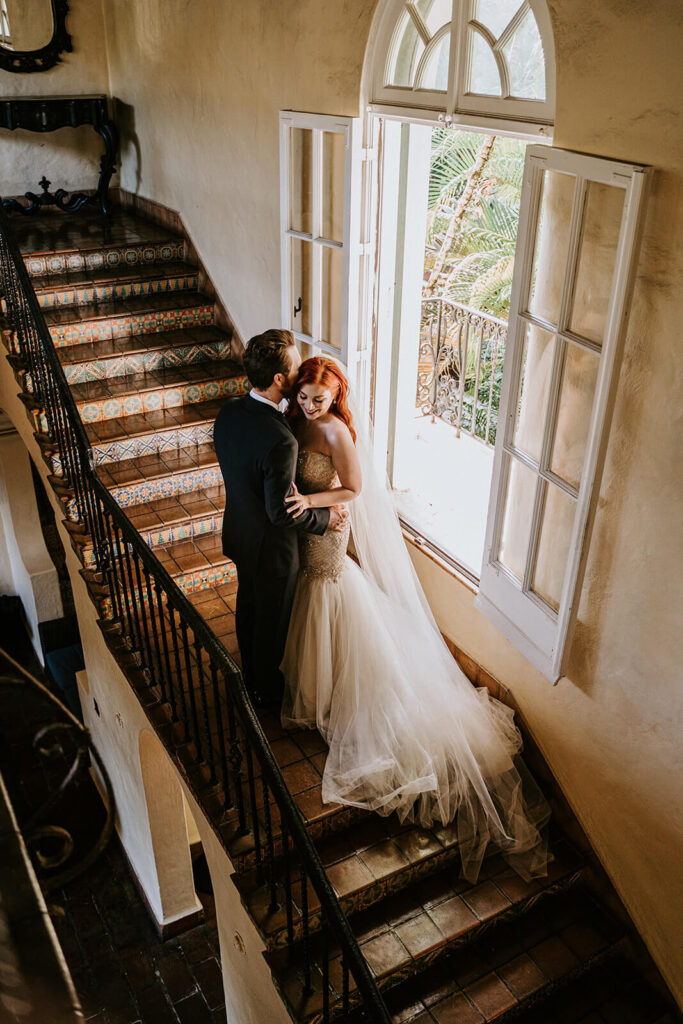 a couple hugs on the stairs at their coconut grove wedding venue 