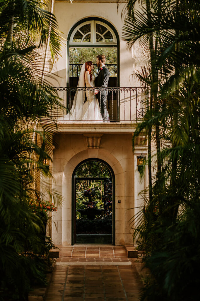 a couple holds hand on the balcony at their wedding venue in Miami