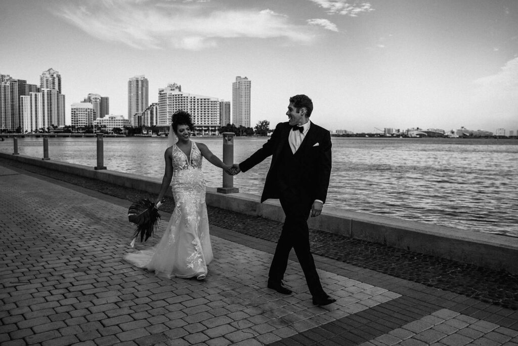 a couple walking around in Downtown Miami on their wedding day in front of their wedding venue