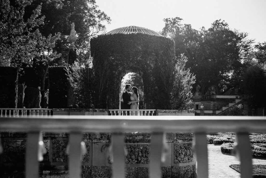 a couple poses in an arch on their wedding day at Vizacya in Miami