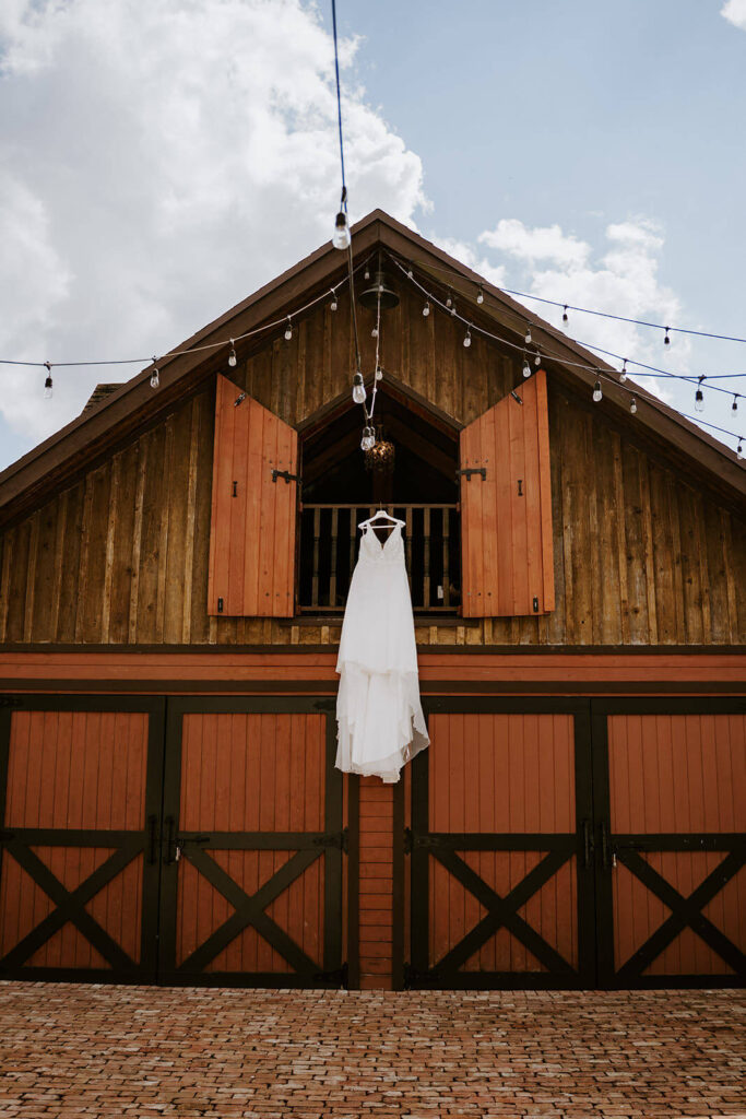 a wedding dress hanging off of a barn at a miami wedding venue