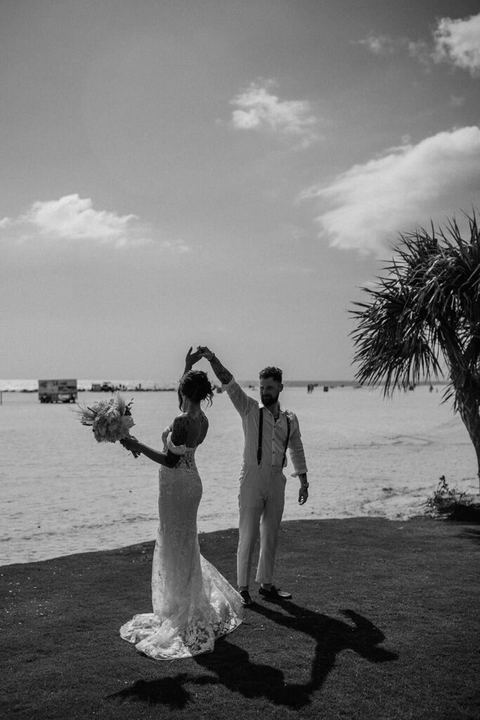 a groom spins his bride at their beachfront miami wedding venye