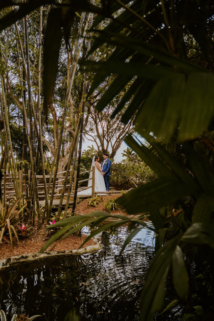 a bride and groom at their first look surrounded by palms at Redland Farmlife