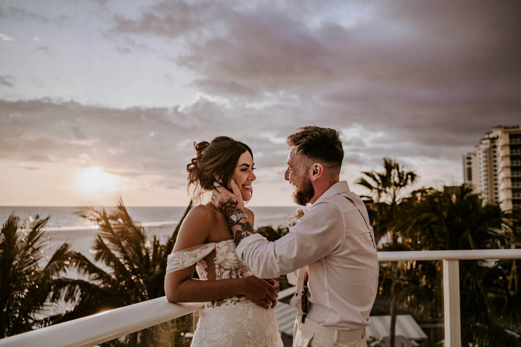 a couple looking at each other on the balcony of their beachfront miami wedding venue on their wedding day