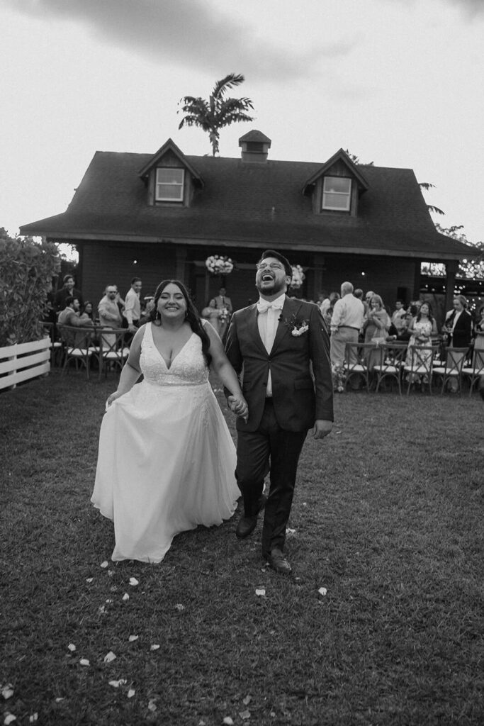 a couple walks after becoming husband and wife while laughing at their miami wedding venue