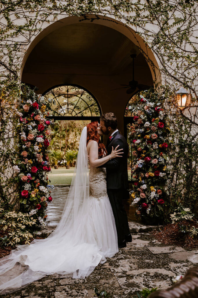 a couple has their first kiss at their wedding ceremony in the courtyard