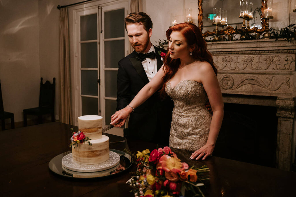 a bride and groom cut their wedding cake