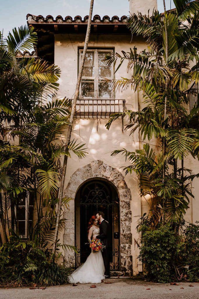 a couple poses outside the beautiful Villa Woodbine in Miami Fl