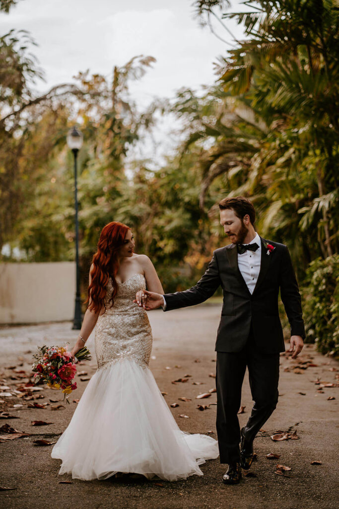 a couple walks hand in hand through their wedding venue 