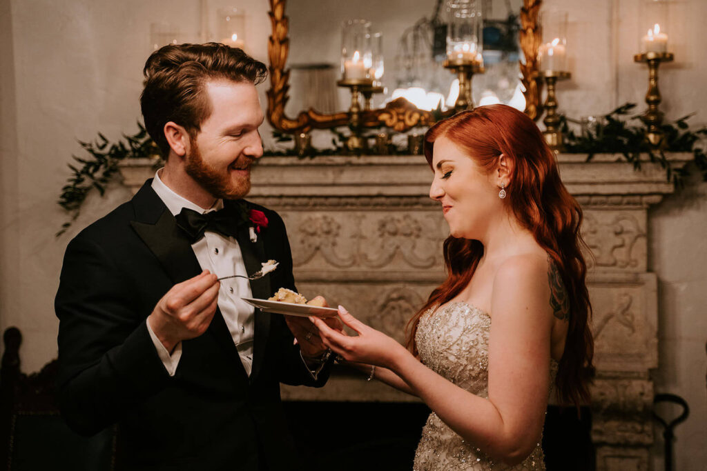 a bride and grooms feed each other wedding cake