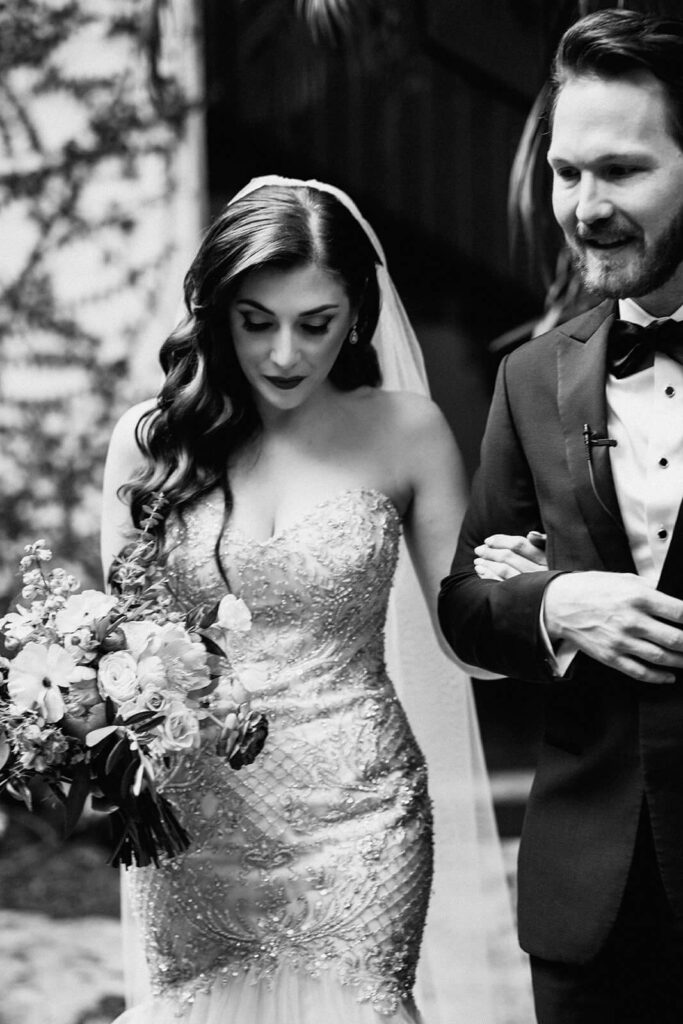 a couple walks into their ceremony together on their wedding day