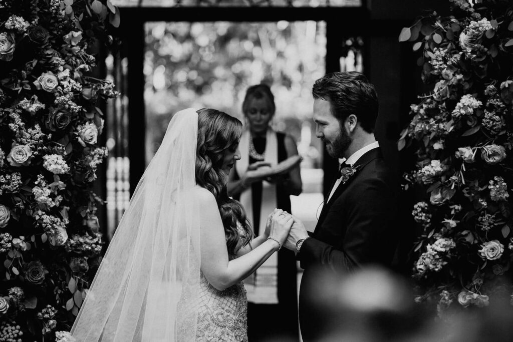 a couple prays during their wedding ceremony holding hands