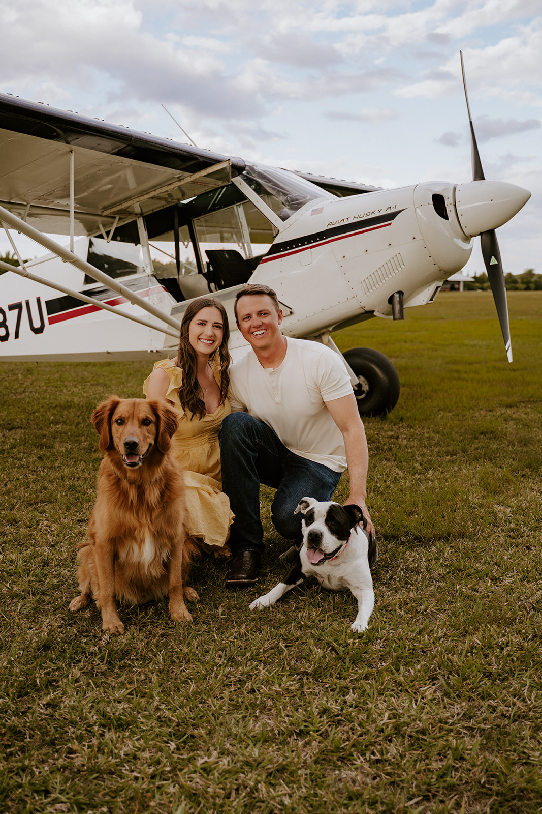 Man and woman pose for engagement photos with their dog