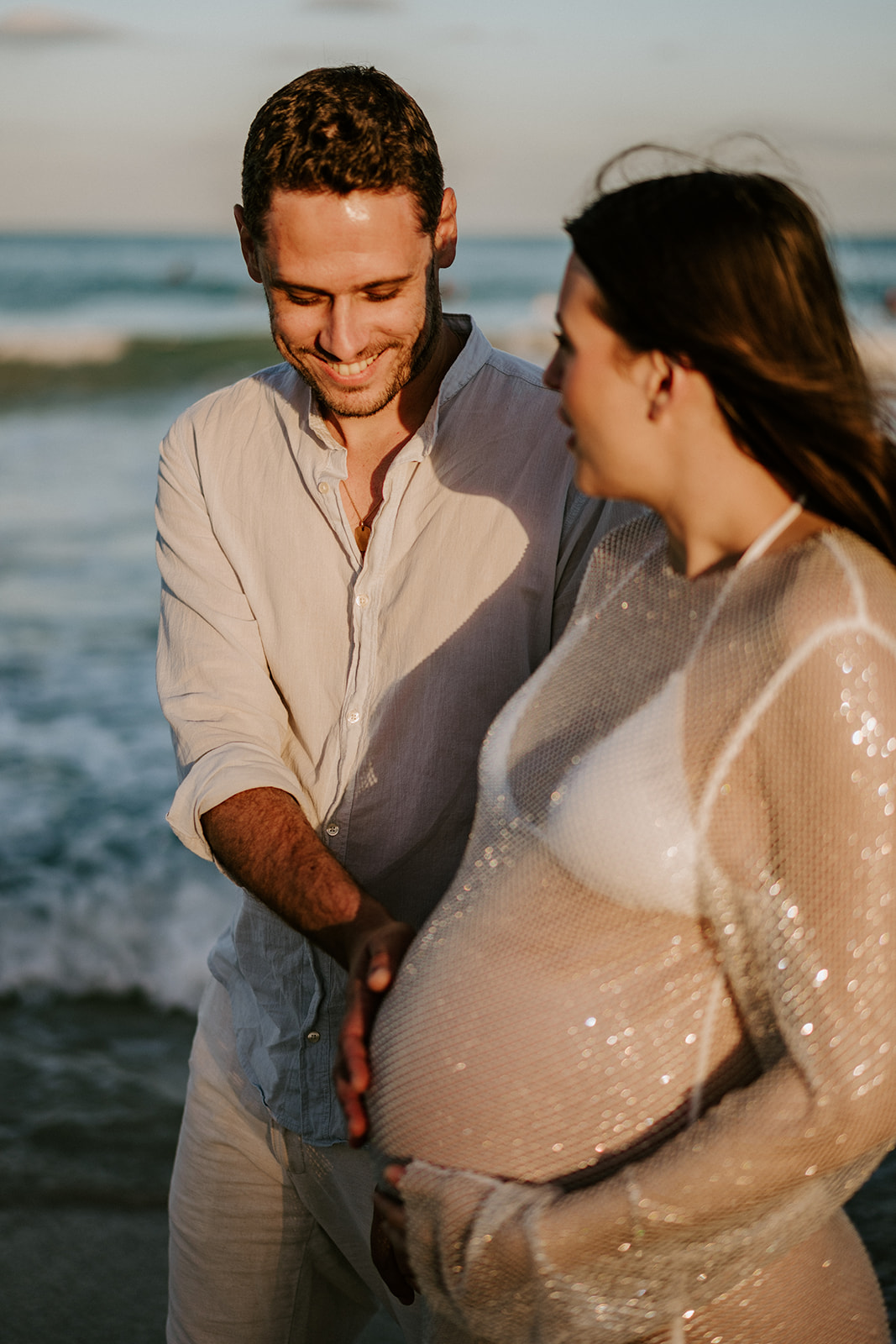 Man and woman at their beach maternity photoshoot in Miami, Florida