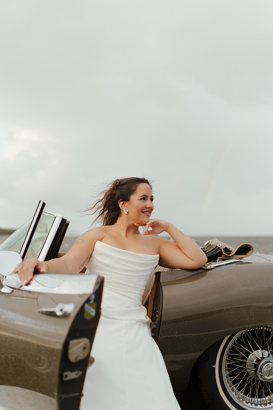 Woman poses with vintage car during engagement session